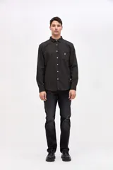 Camisa de corte regular fit, confeccionada en tela de algodón con diseño de rayas verticales finas. Presenta cuello clásico, cierre frontal con botones y un bolsillo en el pecho con el logo de la marca bordado.