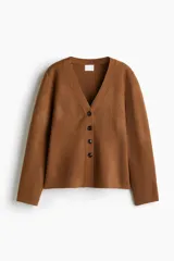 Cárdigan de punto color marrón, con cuello en V y cierre frontal de cuatro botones oscuros. Presenta un calce holgado y mangas largas.