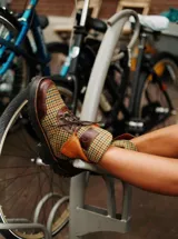 Botas de caña baja con base de terciopelo y paños de tweed a cuadros en tonos marrones, beige y verde. Presentan detalles en cuero marrón y cordones marrones.