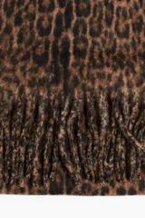 Bufanda de tejido suave y cepillado con estampado de leopardo en tonos marrón y negro. Presenta flecos largos en los bordes.