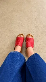 Zuecos de plataforma corrida color rojo con textura símil cocodrilo y suela de madera clara.