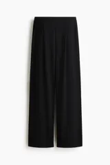 Pantalón ancho de punto color negro, de tiro alto con elástico oculto en la cintura, piernas amplias con pinzas y bolsillos al bies.