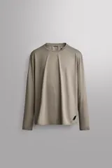 Camiseta deportiva de manga larga Zara Athleticz, de corte regular fit y color marrón topo. Confeccionada en tejido técnico elástico de secado rápido, cuenta con cuello redondo y detalle de logo estampado en el bajo.