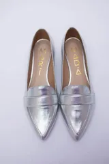 Mocasines negros de cuero con punta fina y detalle de antifaz.