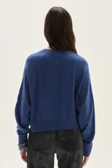 Cardigan de tejido de punto en color azul, con cuello redondo, cierre frontal con botones al tono y mangas largas con puños acanalados. Presenta un diseño clásico y versátil.