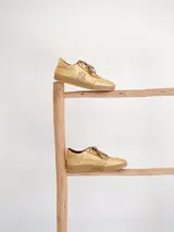 Championes de gamuza color borgoña, beige y naranja con cordones.