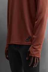 Camiseta deportiva color durazno de manga larga con orificios para los pulgares.