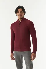 Sweater gris de punto con cuello alto y medio cierre con cremallera.