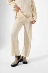 Pantalón de punto color beige, de corte recto y holgado, con diseño de canalé vertical y cintura elástica.