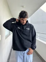 Canguro negro de algodón con capucha y bolsillo tipo canguro. Estampa frontal con la leyenda "Deep Advise" y "Brokers Wear".