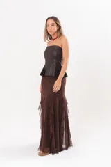 Pollera larga color chocolate confeccionada en microtul, totalmente forrada, con diseño fluido y volados en cascada que aportan movimiento.