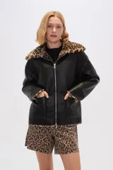 Campera de eco-cuero negra con cuello y puños de animal print, cierre frontal con cremallera y bolsillos laterales.