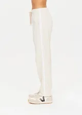 Pantalón deportivo color crema de corte recto con cintura elástica, cordón de ajuste y cinta de rayas plateadas en los laterales.