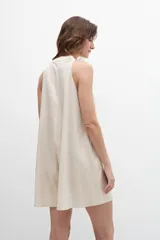 Mono corto de lino color beige, con escote mao y cierre frontal con botones.