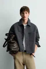 Cazadora relaxed fit de algodón color gris oscuro, con cuello solapa, manga larga con puños abotonados, bolsillos de plastrón en el pecho y cierre frontal con botonadura.