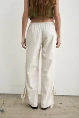 Pantalón recto marrón de lino y algodón, con tiras regulables en los tobillos para ajustar.