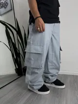 Pantalón cargo celeste de gabardina rígida, corte súper baggy, con bolsillos laterales grandes y bajos.