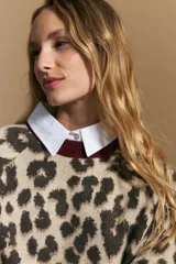 Sweater de tejido jacquard con estampado animal print, de silueta relajada y manga larga. Presenta cuello redondo y bordes en contraste de color bordó.