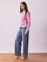 Cardigan de tejido tweed celeste y blanco, con escote redondo, cierre frontal con botones metálicos dorados y bolsillos simulados en el frente.