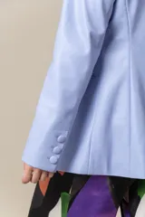 Blazer de cuero color lavanda, con cuello y solapa, bolsillo pequeño en el pecho y dos bolsillos con tapa en el frente.