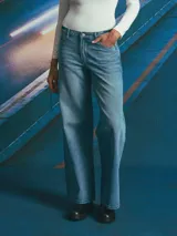 Jean de corte recto y tiro medio, confeccionado en denim de tono azul medio con costuras en contraste. Presenta diseño de cinco bolsillos y cierre frontal con botón metálico.