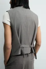 Chaleco de traje regular fit confeccionado en tejido con lana, con cuello en pico, cierre frontal de botones y bolsillos de vivo en la cintura. Presenta forro interior con diseño de rayas.