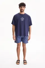 Remera azul marino de manga corta, con corte semi boxy y estampado frontal en color blanco que incluye un globo terráqueo y la palabra 'OFFLINE.'