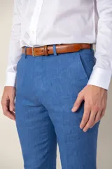 Pantalón de lino azul, de corte clásico y recto, con bolsillos laterales y trabillas para cinturón.