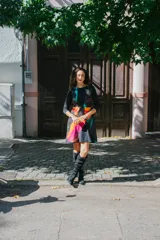 Vestido corto negro con estampado abstracto multicolor y mangas largas.