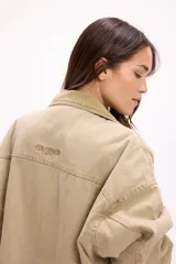 Campera de denim en tono marrón con diseño vintage, corte relajado, cuello de pana y bolsillos delanteros con solapa.