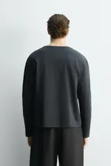 Camiseta de manga larga con cuello panadero y cierre frontal de botonadura, de corte relajado.
