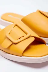 Sandalias planas Paddock modelo Amelias, de color negro con textura efecto cocodrilo. Presentan una tira ancha en el empeine decorada con una hebilla grande cuadrada del mismo material y tono.