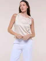Blusa de satén color negro, de corte fluido, con escote asimétrico y un aro metálico decorativo en el hombro.