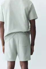 Short deportivo color verde claro, de corte regular, con cintura elástica ajustable con cordón, bolsillos laterales y un bolsillo trasero.