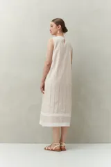 Vestido largo blanco de algodón con calados verticales y bordado tipo ojo de perdiz, sin mangas y de silueta recta.