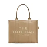 Bolso tipo tote de gran tamaño, confeccionado en cuero negro con textura granulada. Presenta el logo de la marca estampado en el frente con la inscripción The Tote Bag Marc Jacobs. Cuenta con asas superiores resistentes y un diseño espacioso.