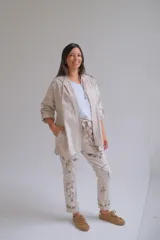 Campera tipo parka de color beige, con cierre frontal completo, capucha con cordones ajustables y mangas tres cuartos con detalle de trabilla y botón.