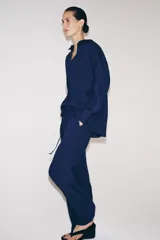 Pantalón de tiro medio con diseño de pierna ancha y textura acanalada. Cuenta con cintura elástica ajustable mediante cordones.