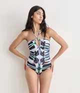 Malla entera con estampado abstracto en blanco, negro, verde, violeta y rosa. Diseño halter con escote en V y detalle de argolla en el centro del busto.