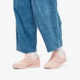 Championes urbanos New Balance modelo WL574, color rosado monocromático, confeccionados en gamuza y material sintético, con logo "N" característico en los laterales y entresuela ENCAP.