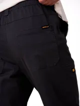 Pantalon de corte utilitario color negro, confeccionado en tejido stretch. Presenta cintura elástica con cordón de ajuste, bolsillos laterales de entrada, bolsillo utilitario en la pierna derecha y remaches metálicos en los bolsillos.