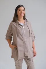 Campera tipo parka liviana color visón, con cierre frontal, capucha con cordones ajustables y mangas 3/4 con detalle de trabilla. Presenta un diseño holgado y casual.