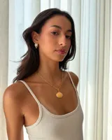 Collar de cadena de acero con baño de oro y dije de concha marina natural.