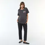 Camiseta de lactancia color negro, con cuello redondo y mangas cortas. Presenta un estampado frontal con el texto 'Mom Club' y un corazón rojo, además de cierres laterales ocultos para facilitar la lactancia.