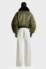 Jean de tiro alto con corte wide leg, confeccionado en denim rígido de color blanco. Presenta diseño clásico de cinco bolsillos, cierre frontal con botón y ruedo con terminación desflecada.