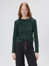 Remera de manga larga con cuello a la base, confeccionada en tejido de punto acanalado color beige. Presenta un logo bordado en el centro del pecho.