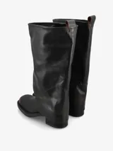 Bota de caña alta confeccionada en cuero negro con un diseño de caña doble o superpuesta que cubre el talón. Presenta una silueta recta de estilo minimalista, punta redondeada y taco bajo cuadrado.