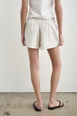 Short color crudo de tiro bajo, con pretina elástica y detalles laterales en marrón y verde militar.