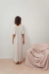 Vestido midi color blanco crudo, con escote en V, fruncido en el pecho y mangas cortas abullonadas.