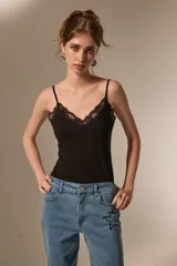 Body de breteles finos color blanco, con escote en V y detalle de encaje en el borde superior. Confeccionado en poliéster, presenta un diseño ajustado al cuerpo con cierre de broches en la parte inferior.